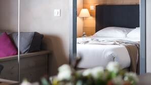 Habitación de hotel con cama, lámpara de noche y una pared de madera.