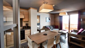 Una cocina moderna con armarios de madera, una mesa de comedor con sillas y un balcón con vistas.