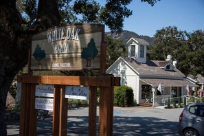 A sign for White Oak Plaza with a view of a building and trees in the background.