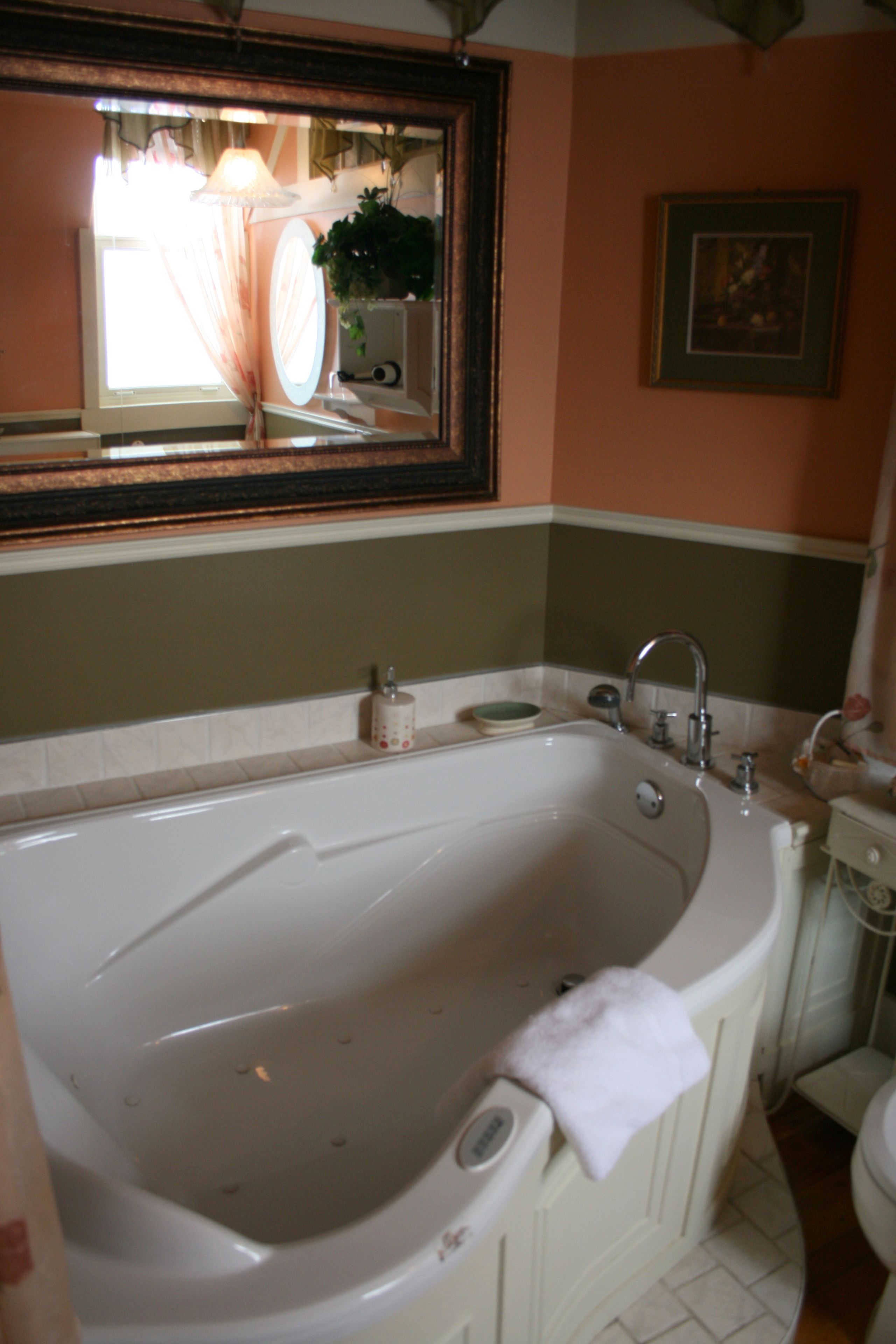 Une salle de bain avec une grande baignoire, un lavabo et des toilettes.
