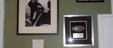 A wall with four framed photographs and a plaque.