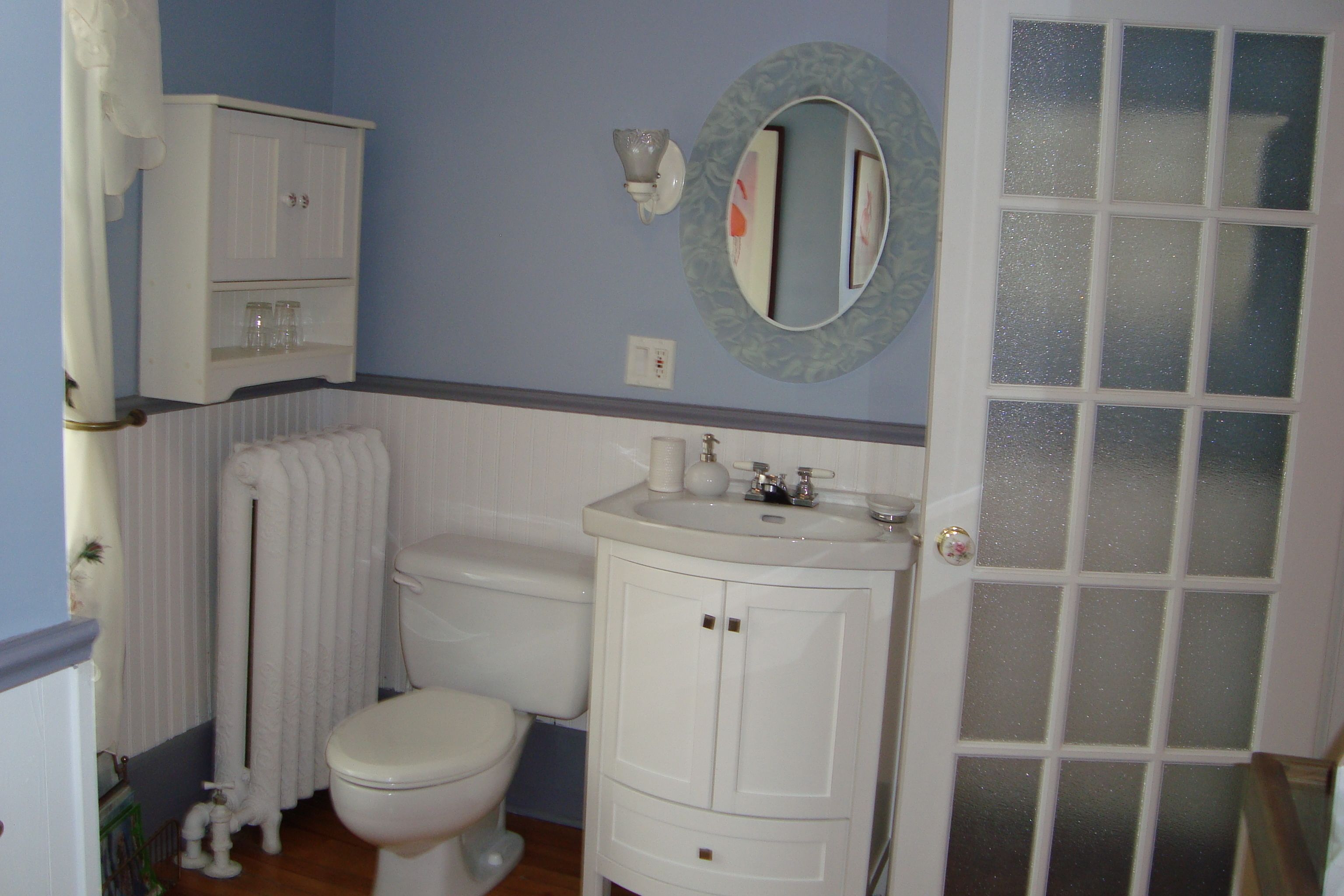 Une salle de bain avec des toilettes, un lavabo et un meuble.