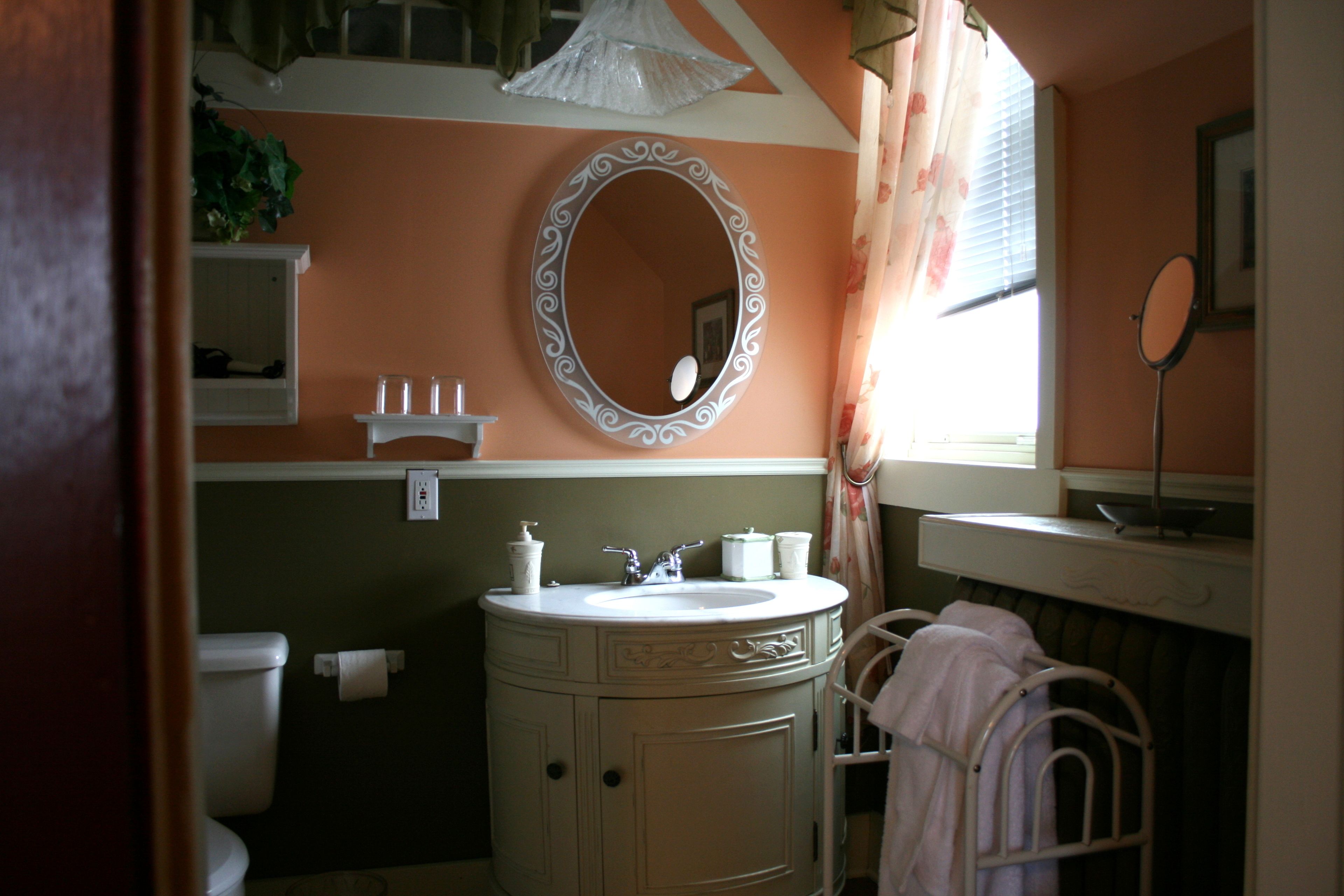 A bathroom with a sink, mirror, and towel rack.