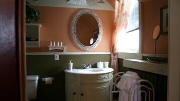 A bathroom with a sink, mirror, and towel rack.