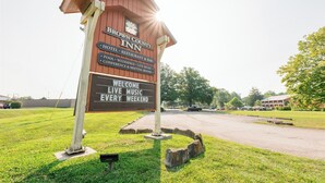A Brown County Inn sign with amenities like a hotel, restaurant, bar, pool, weddings, live music, and conference rooms. - Brown County Inn (Nashville)