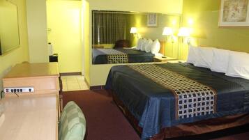 A hotel room with a bed, bedside lamps, a mirror, a desk, and a chair.