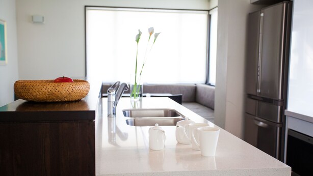 A modern kitchen with a large island, stainless steel appliances, and a view to the living area. - Neyuki (Kutchan)