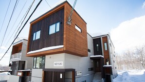 A modern multi-story building with a wooden facade and a sign reading "NEYUKI". - Neyuki (Kutchan)