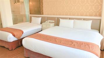 Habitación de hotel con dos camas, un teléfono en la mesita de noche y una pequeña mesita auxiliar.