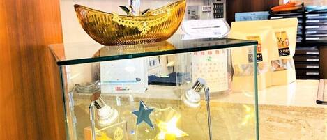 Un expositor de vidrio con premios y un cuenco decorativo.