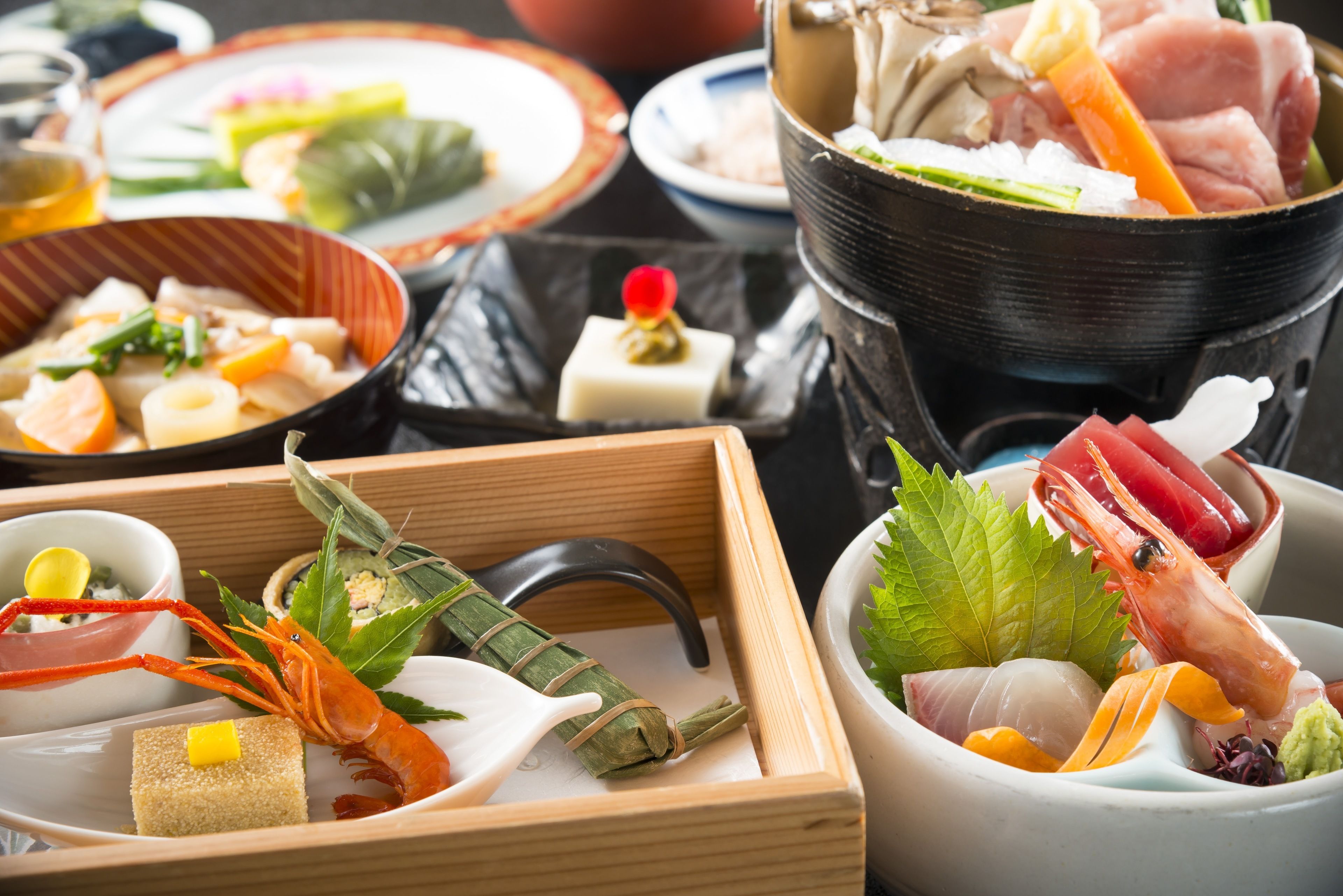 A variety of dishes including seafood, vegetables, and a hot pot setup.