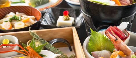 A variety of dishes including seafood, vegetables, and a hot pot setup.
