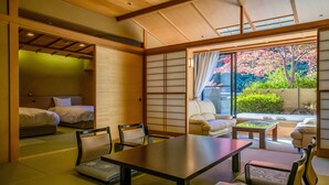 A traditional Japanese-style room with tatami flooring, a low table, and a view of cherry blossoms outside. - Fukuichi (Shibukawa)
