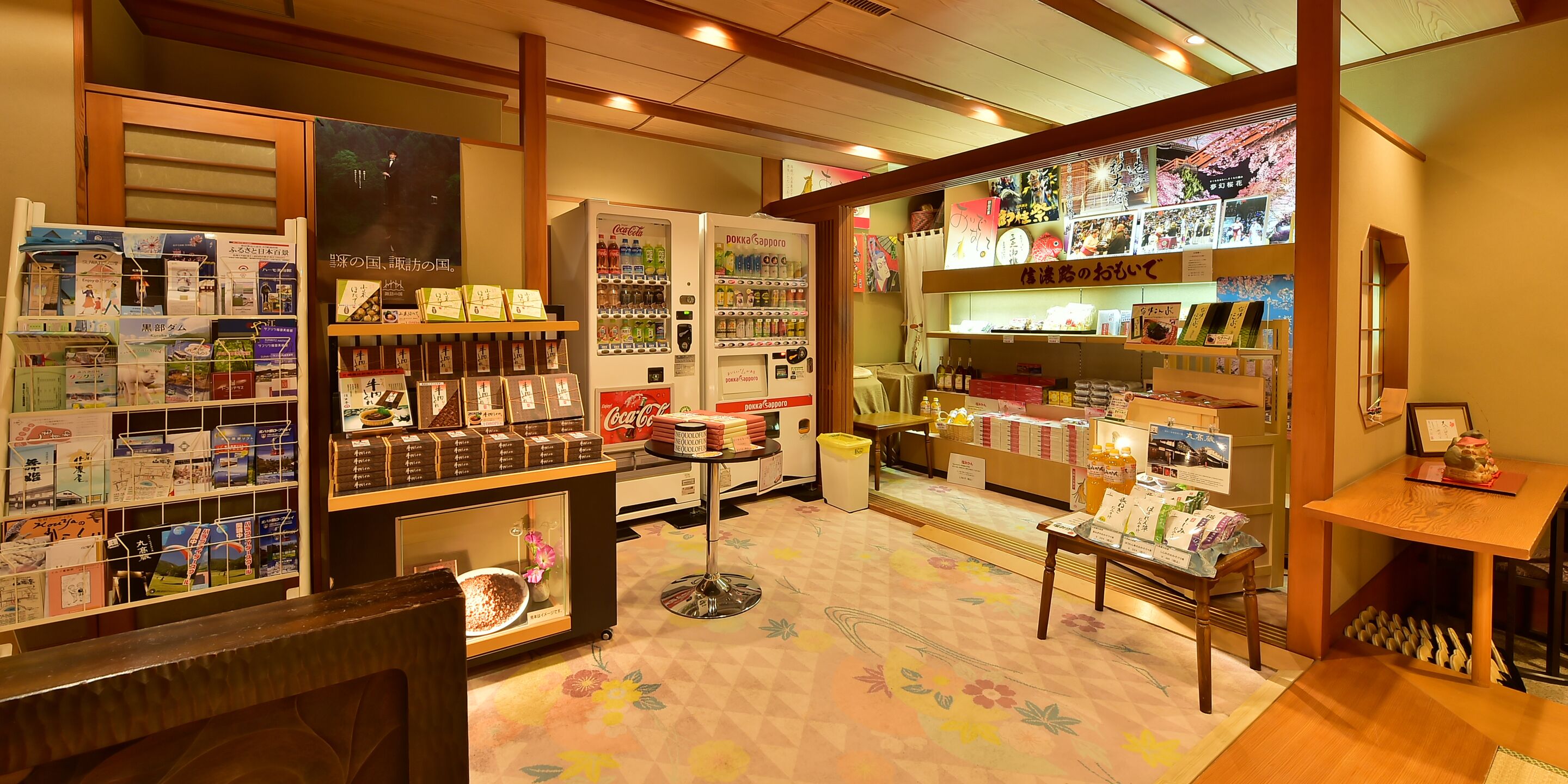A bookstore with shelves of books, a Coca-Cola vending machine, and a display of postcards.