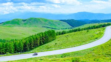 A winding road through a green landscape with hills and trees.