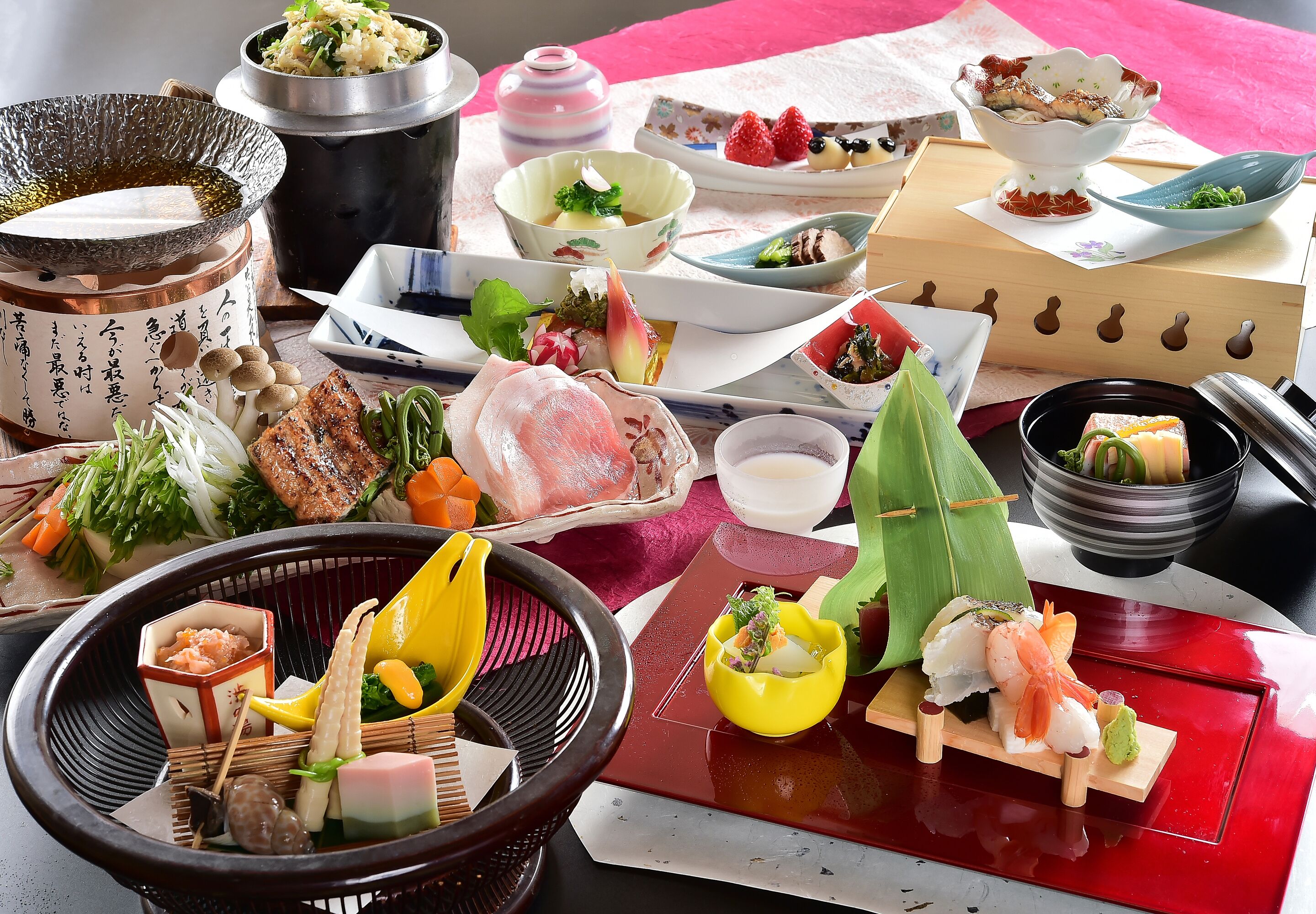 A variety of Japanese dishes arranged on a table, including sushi, sashimi, and other delicacies.