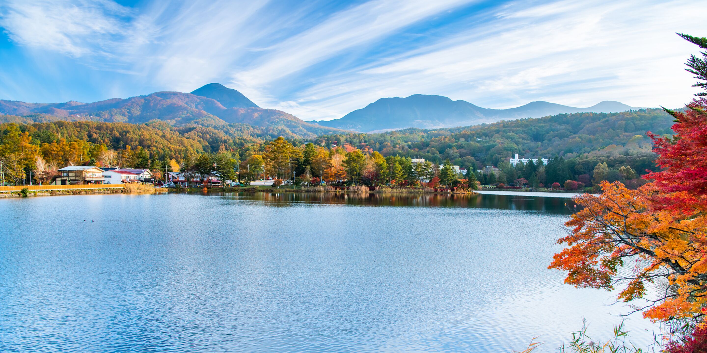 A lake surrounded by mountains and autumn foliage.