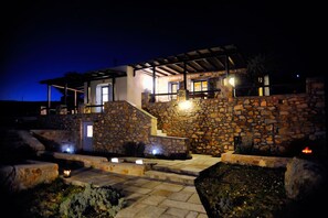 A stone house with a covered porch and steps leading to the entrance.