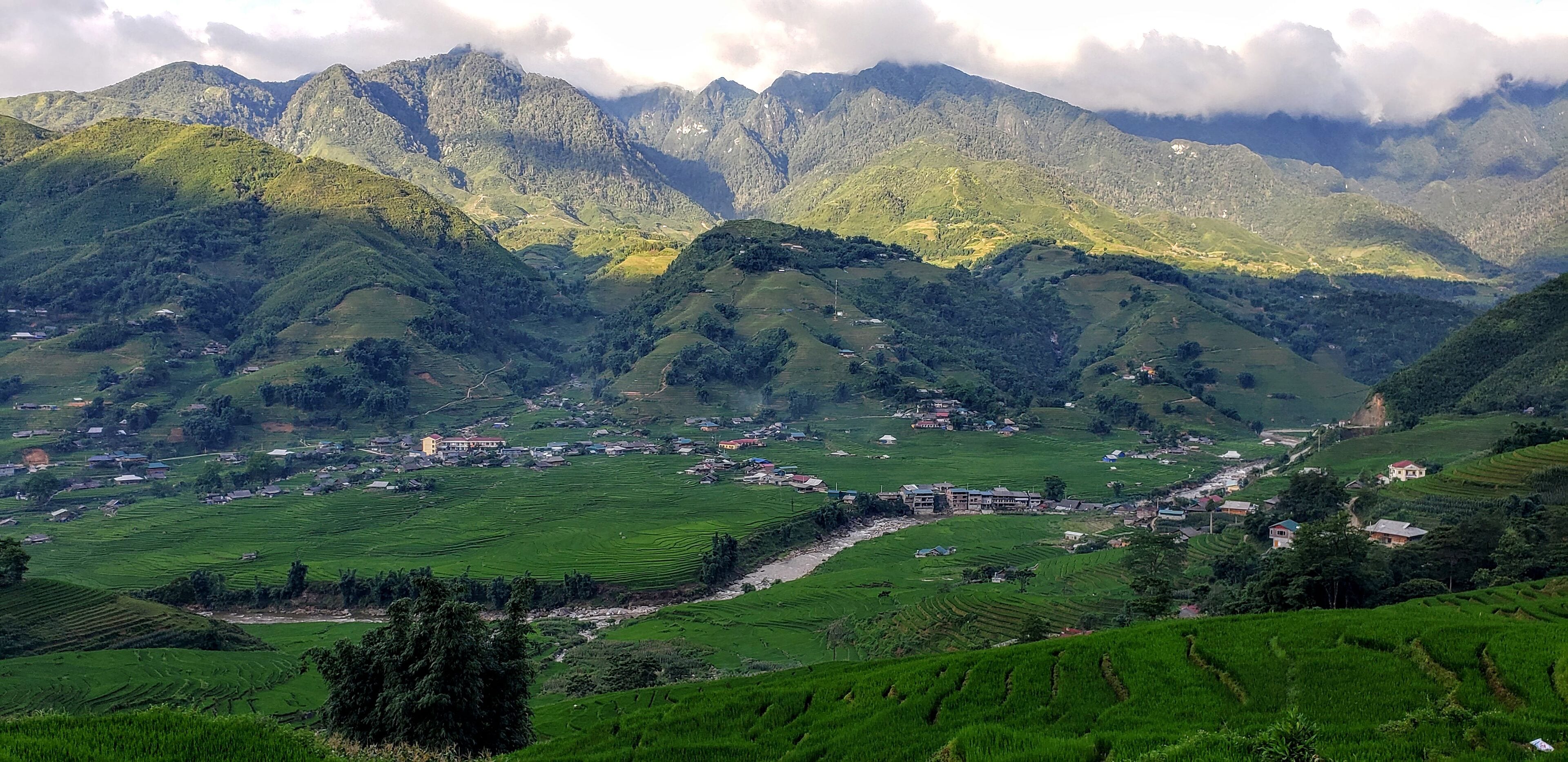 A mountainous landscape with terraced fields and scattered buildings.