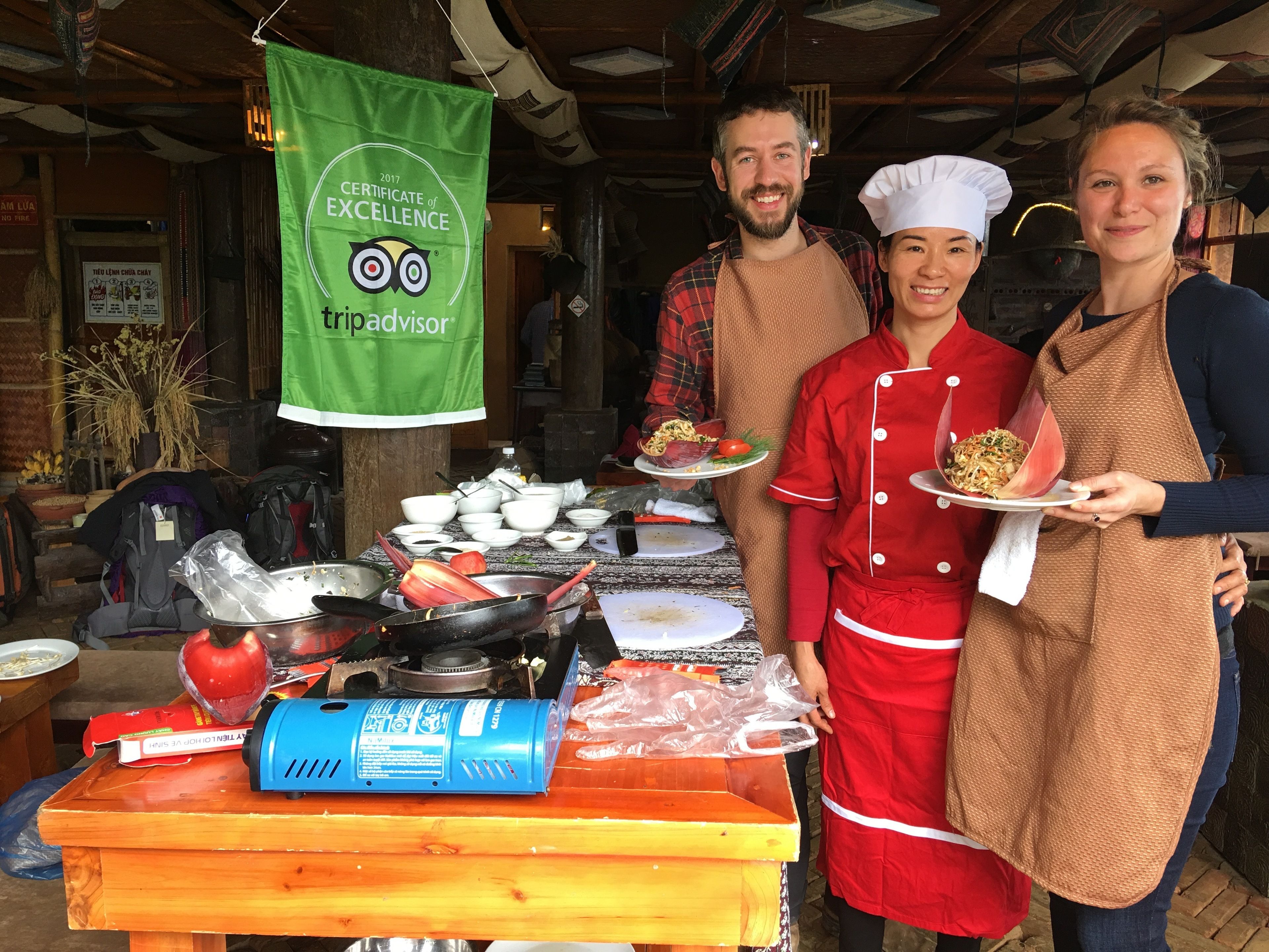 Un grupo de personas con uniformes de chef de pie frente a una mesa con equipo de cocina y platos.