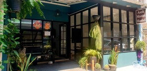 Esquina de un edificio con un letrero que dice "Asok Monti Hostel".