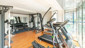 A gym with treadmills, weight machines, and dumbbells. - The Hub Hotel (Yangon)