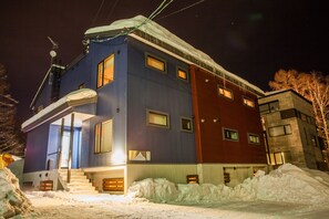 A multi-story building with a mix of exterior colors, including blue, red, and beige. - Yuki Yama (Kutchan)