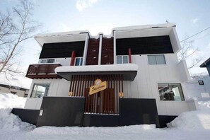 A modern two-story building with a sign reading "Shirokuma." - Shirokuma 1 (Kutchan)