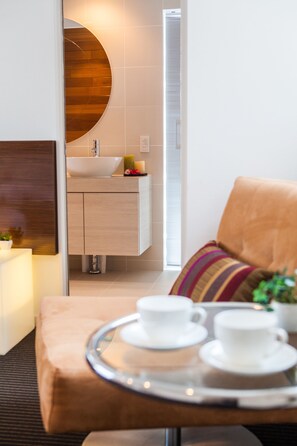 Un baño moderno con tocador de madera, un espejo redondo y un lavabo blanco.