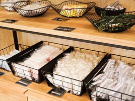 A food display with various packaged items in wire baskets and trays.