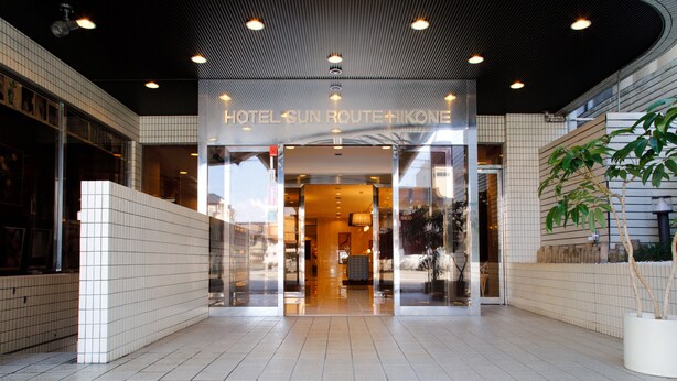 The entrance of a hotel with a tiled floor and a modern ceiling design.