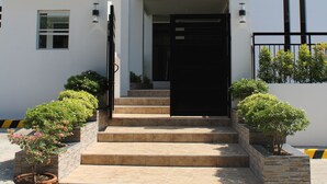 A modern two-story building with a staircase leading to the entrance. - Be-ing Suites (Davao)