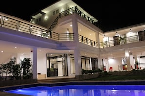 A multi-story hotel with a swimming pool, balconies, and outdoor seating. - Be-ing Suites (Davao)