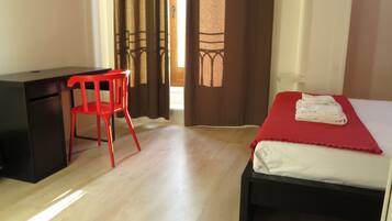 Una habitación con una cama, un escritorio y una silla.