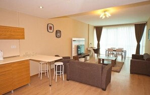 Deluxe suite, 1 tweepersoonsbed met slaapbank | Woonkamer | Een flatscreentelevisie