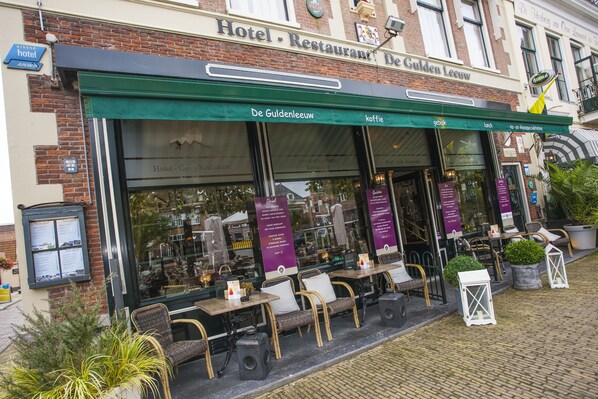 A restaurant with outdoor seating, a green awning, and a sign reading "Hotel - Restaurant De Gulden Leeuw." - De Gulden Leeuw (Workum)
