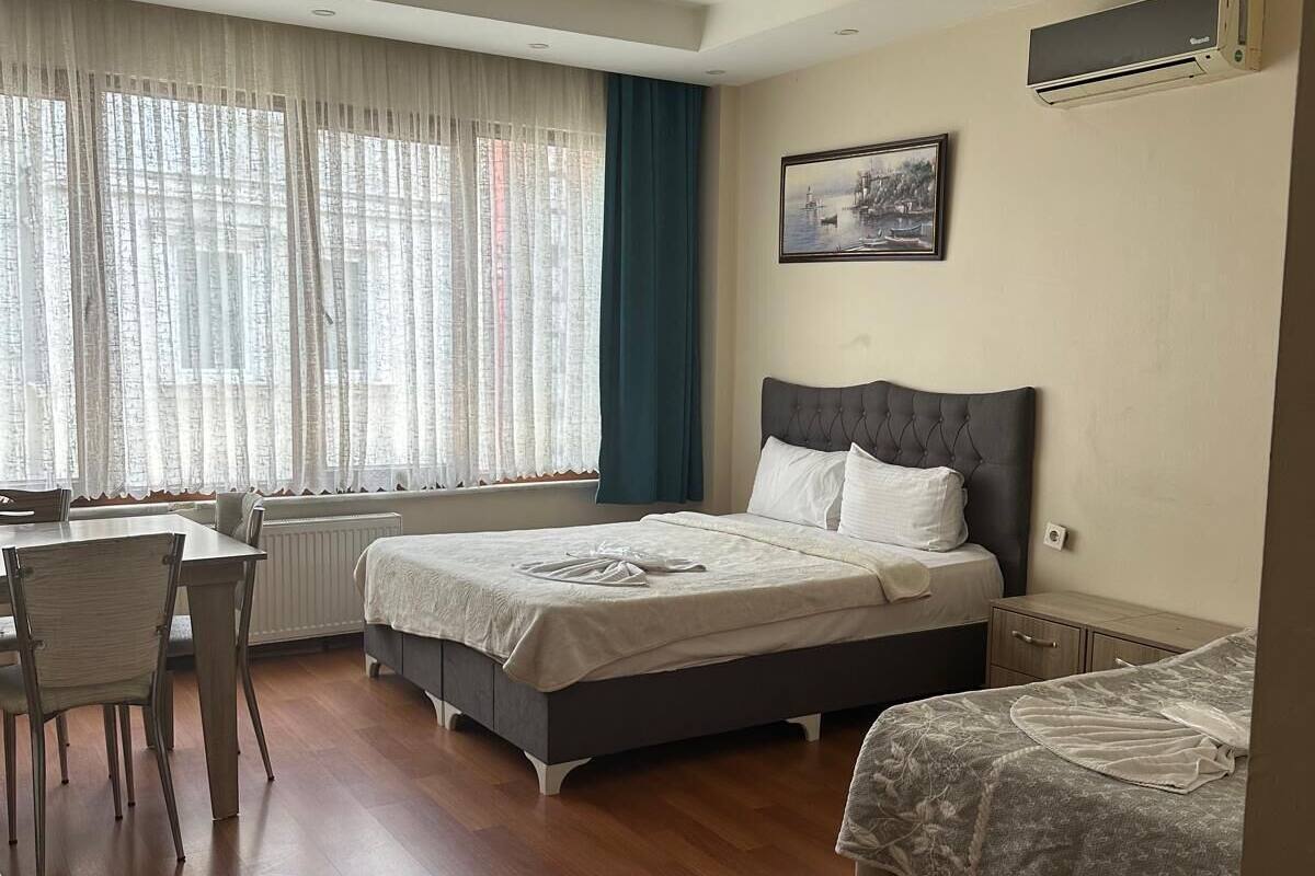 A hotel room with a bed, a desk, and a chair.