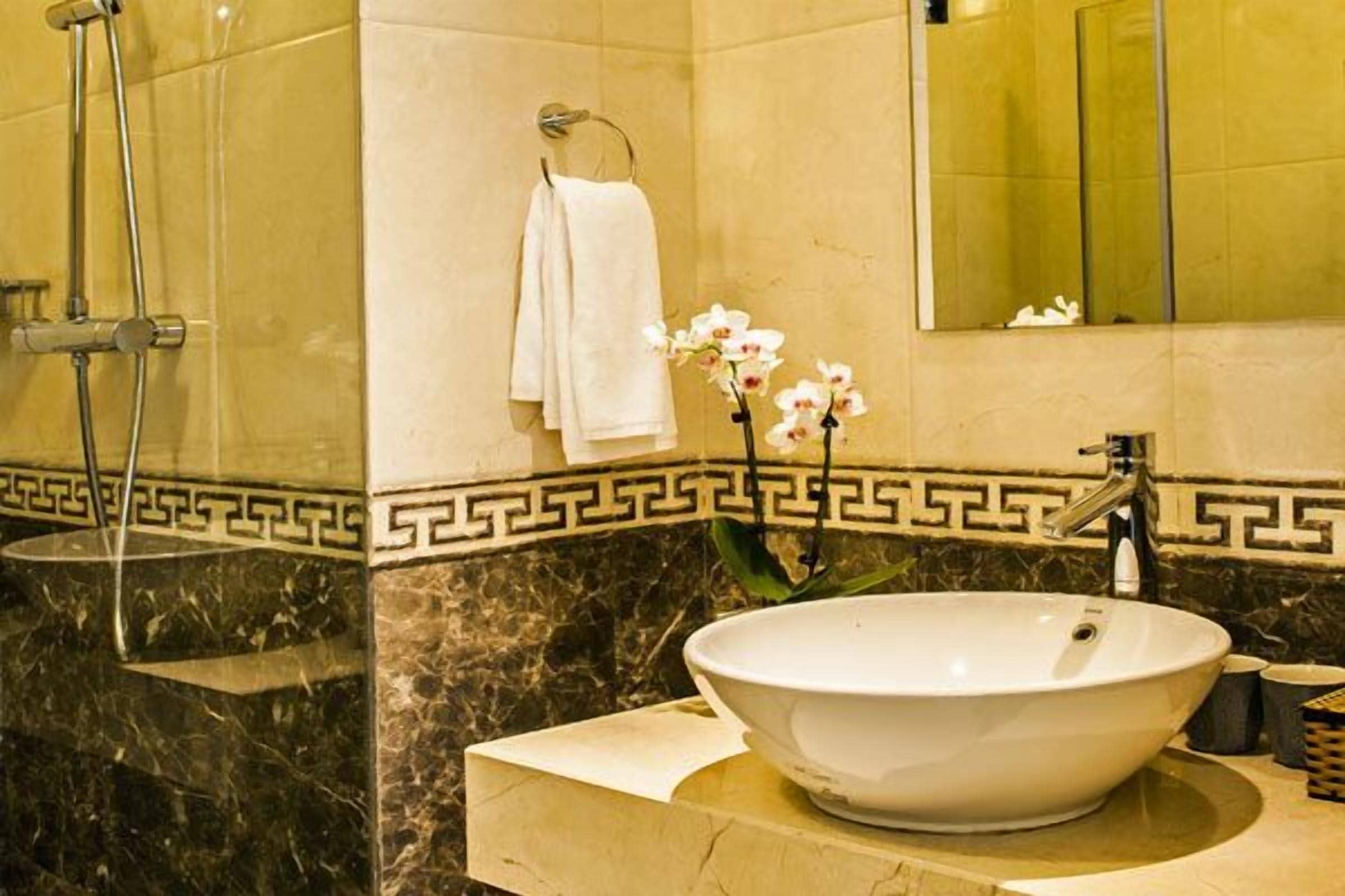 Un baño con un lavamanos grande blanco, un espejo y una ducha.