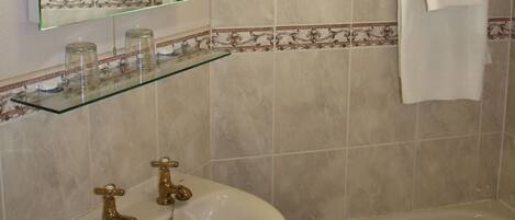 Ein Badezimmer mit Waschbecken, Spiegel und Badewanne.