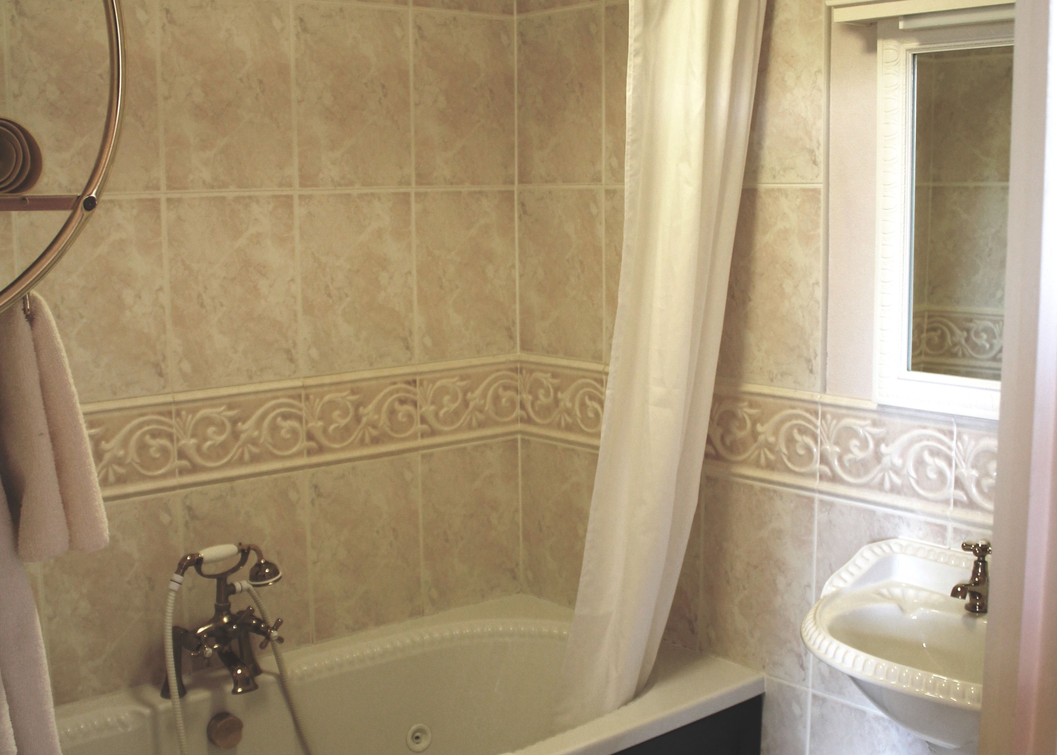 Un baño con bañera, lavabo y cortina de ducha.
