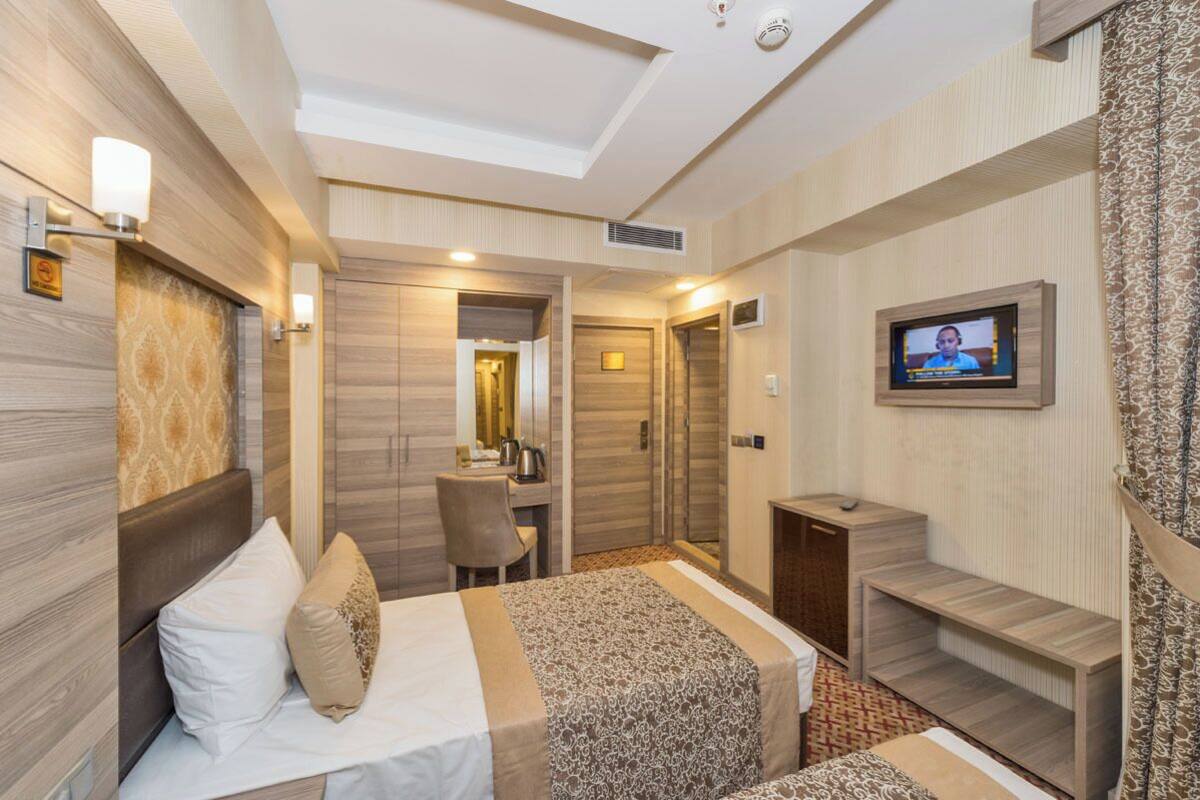 Ein Hotelzimmer mit Bett, Schreibtisch, Fernseher und Dusche.