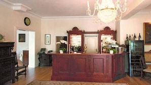 A spacious living room with a wooden coffee table, a chandelier, and a large mirror. - Landhaus Bode (Lübeck)
