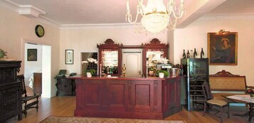 Un salón amplio con una mesa de centro de madera, una araña y un espejo grande.
