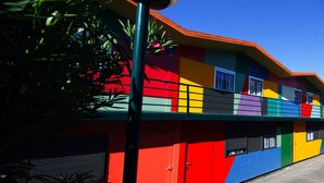 A colorful building with a flat roof and multiple windows. - Compostela Inn (Teo)