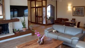 A spacious living room with a fireplace, a sofa, and a dining area.