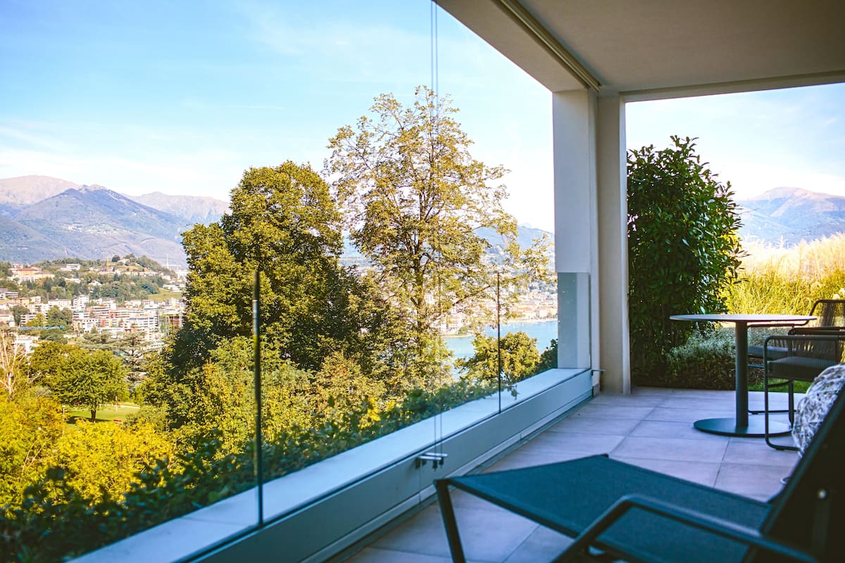 A balcony with a view of mountains and a cityscape.
