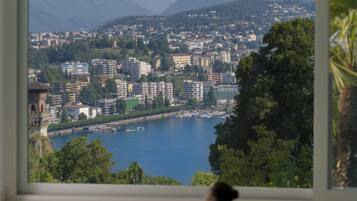 A person in a swimming pool with a view of a cityscape and mountains in the background.