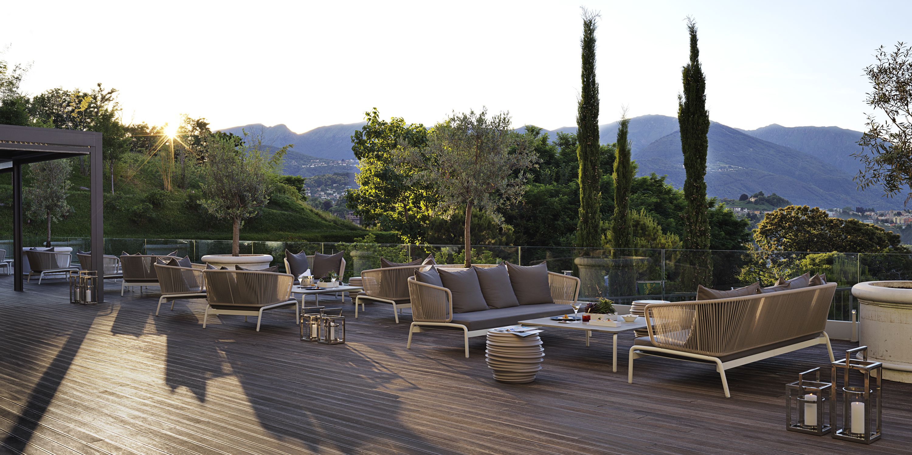 Terraza en la azotea con mobiliario exterior, una pérgola y vistas a las montañas.