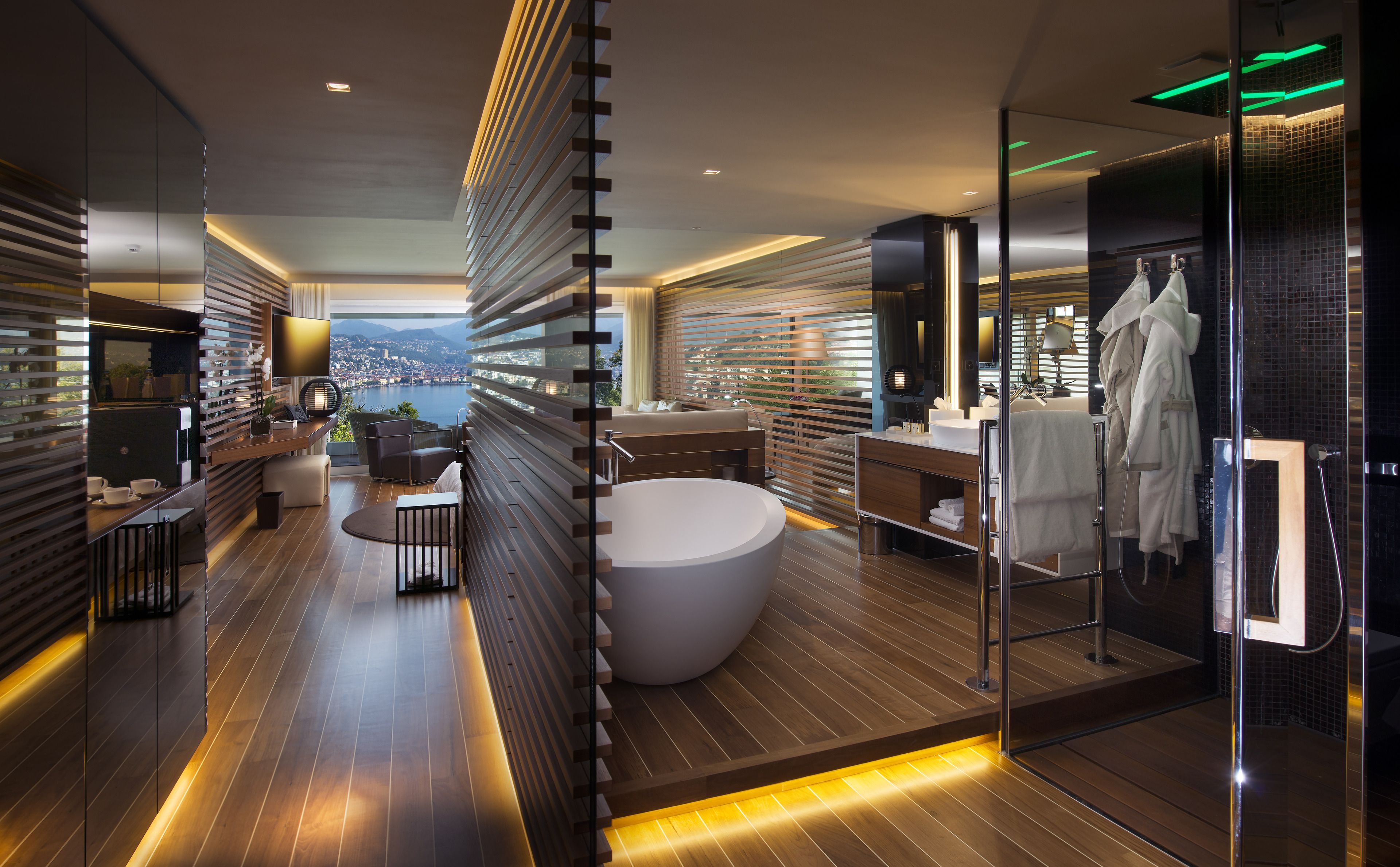 A modern bathroom with a large bathtub, a glass-enclosed shower, and a view of a cityscape.