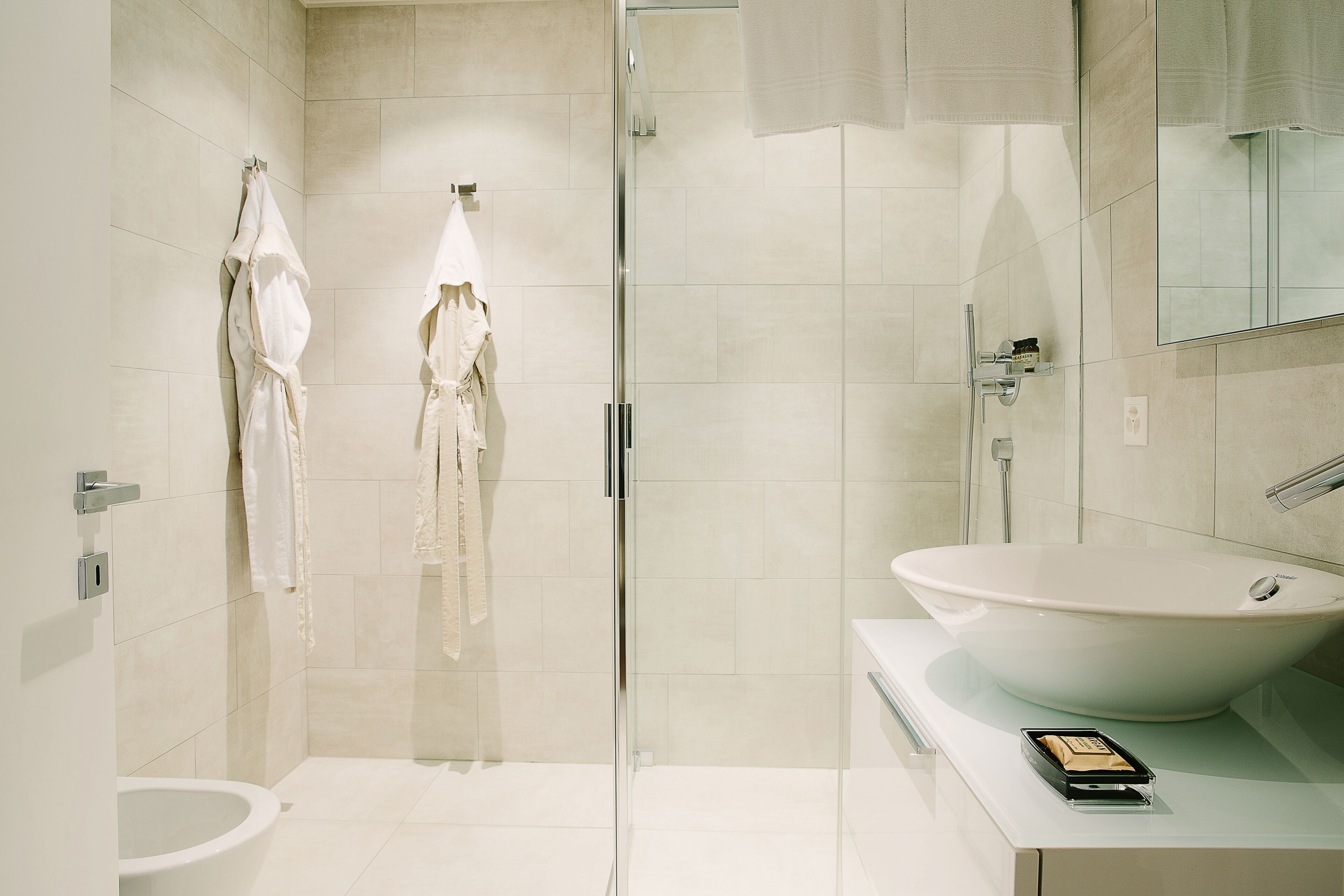 Une salle de bain moderne avec une douche à parois de verre, un lavabo blanc et des toilettes.